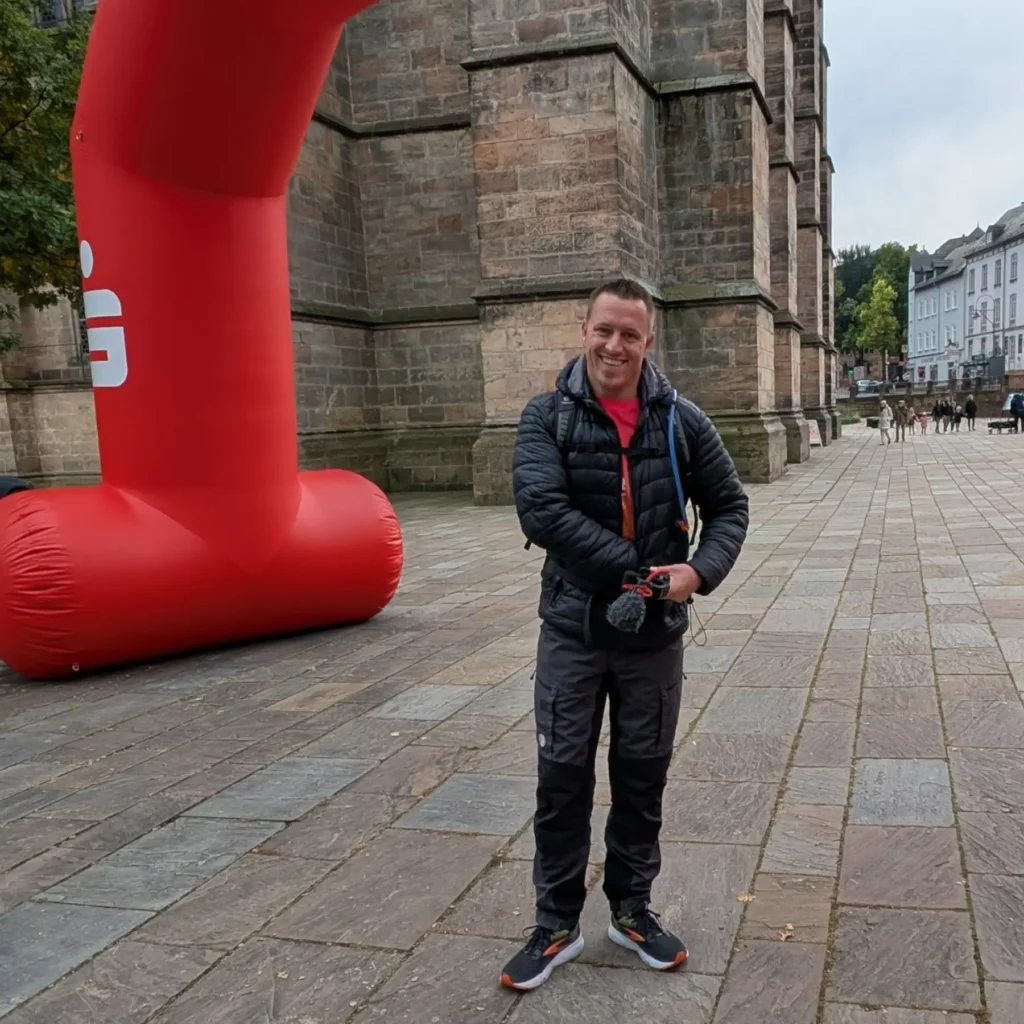 Wanderer vor Start mit guter Laune vor Torbogen.