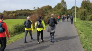 Training für eine Extremwanderung Gruppe Wanderer von hinten auf Asphalt